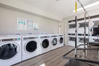 a laundry room with washers and dryers and a cart